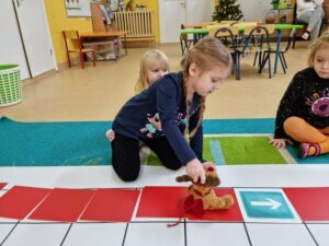 Dziewczynka przesuwa Renifera po polach gry planszowej