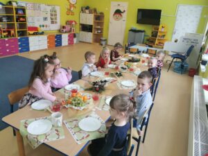 Dzieci siedzą przy wigilijnym stole