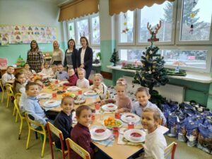 Dzieci siedzą przy wigilijnym stole