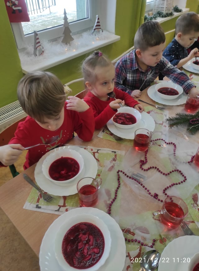 Dzieci siedzą przy wigilijnym stole