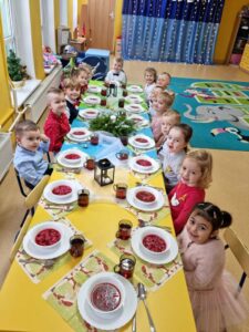Dzieci siedzą przy wigilijnym stole